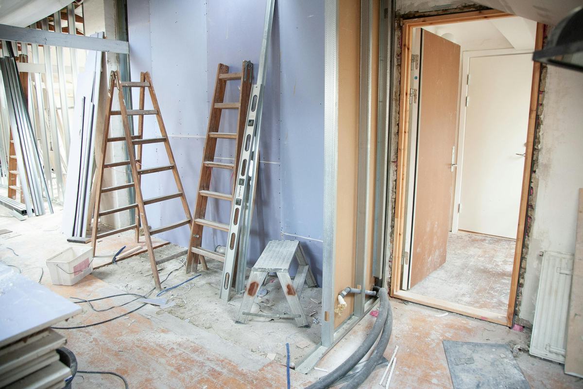 Construction site with stepladders, wall panels and doors waiting to be installed